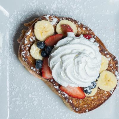 Stuffed French Toast topped with fruits and whipped cream.