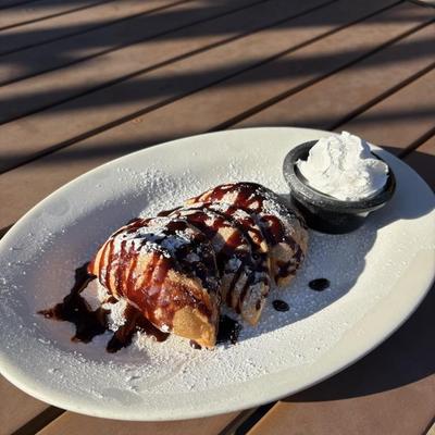 chocolate stuffed empanada with a drizzle of chocolate sauce and a side of whipped cream?.