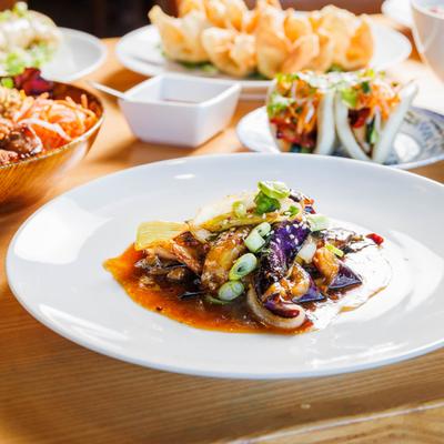 Eggplant sauteed with fresh garlic, served on a plate among other dishes