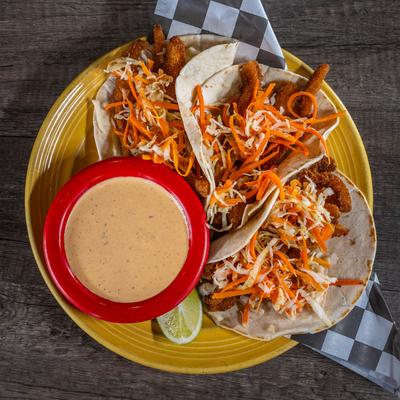 Fish tacos with Mexican chili crema on the side, top view.