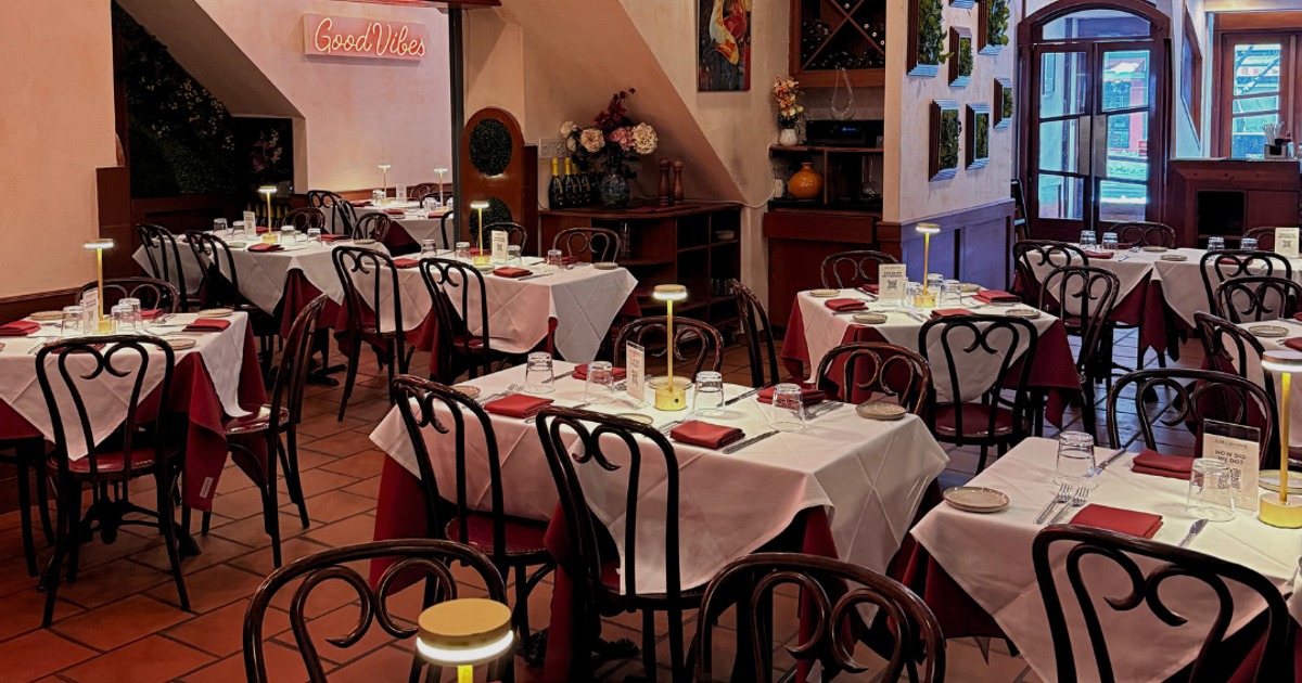 Restaurant dining room with white tablecloth tables and small lamps