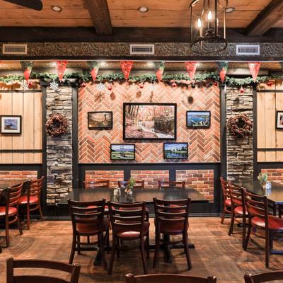 Dining room with tables, chairs, and a wall decoraterd with framed art.