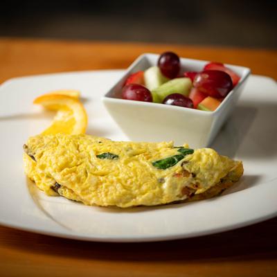 Veggie omelet with fresh fruit on the side.