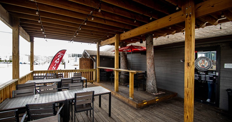 Exterior, patio, covered seating area, tables for six, restaurant entrance, lanterns