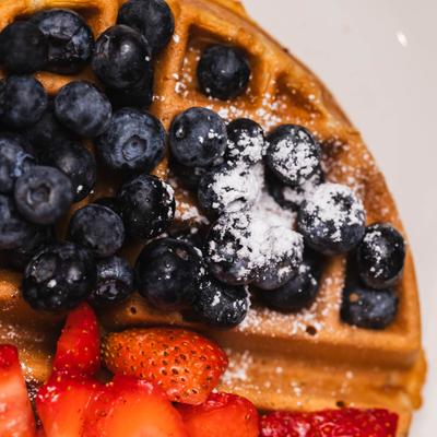 Belgian Waffle topped with blueberris and strawberries, close-up.