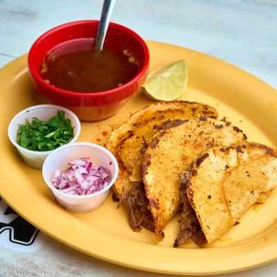 Birria and cheese tacos, served with onion, cilantro, and broth.