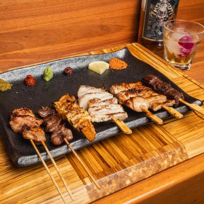 Skewers of bite-sized grilled pieces of meat, served with various condiments.