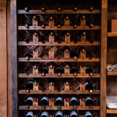 Wine rack filled with bottles inside a wooden cabinet.