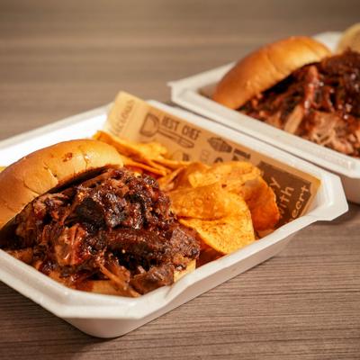 Barbecue sandwich served with potato chips.