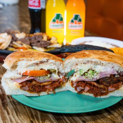 Marinated pork sandwiches, with cheese, lettuce, tomato, onions, and avocado.