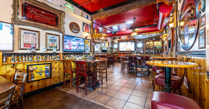 A cozy pub interior with red ceilings, and wooden furnishings