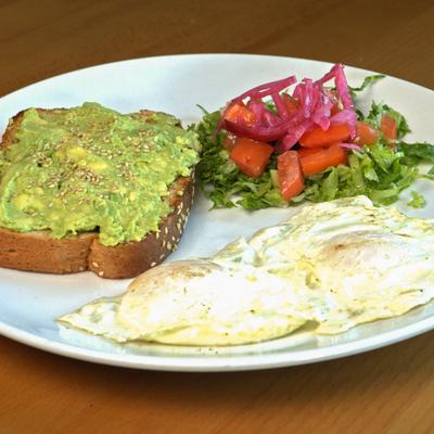 Avocado toast, fried eggs, and salad.