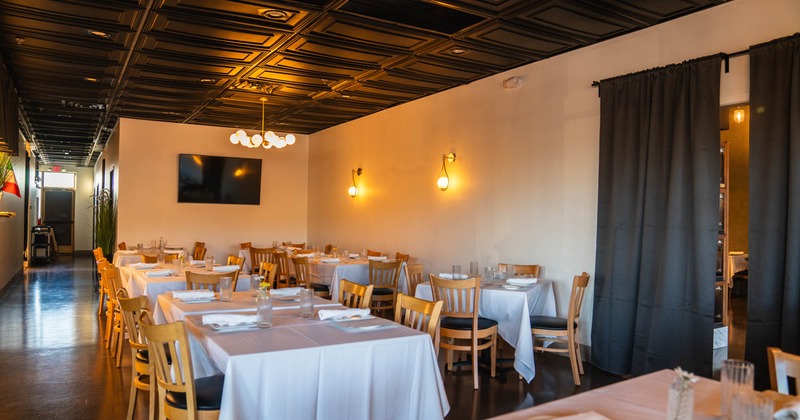 Interior, tables for four with wooden chairs, ready for guests, vintage wood coated ceiling