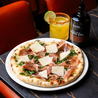 Prosciutto pizza paired with a margarita drink.