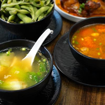 Soup served with edamame and side dishes.