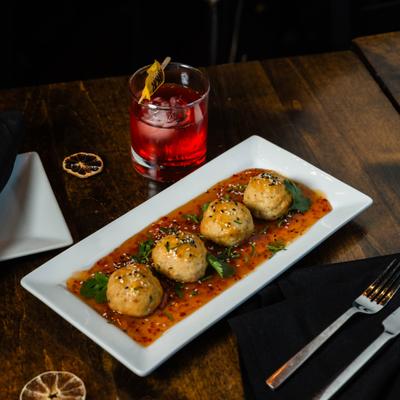 Asian chicken meatballs served with sauce on a rectangular plate.
