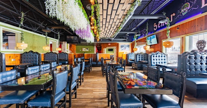 Interior with blue cushioned seating, hanging floral decorations, and wooden accents