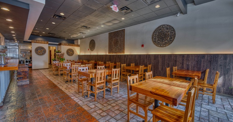 Interior, dining area, wooden tables and chairs, mandala wall decorations