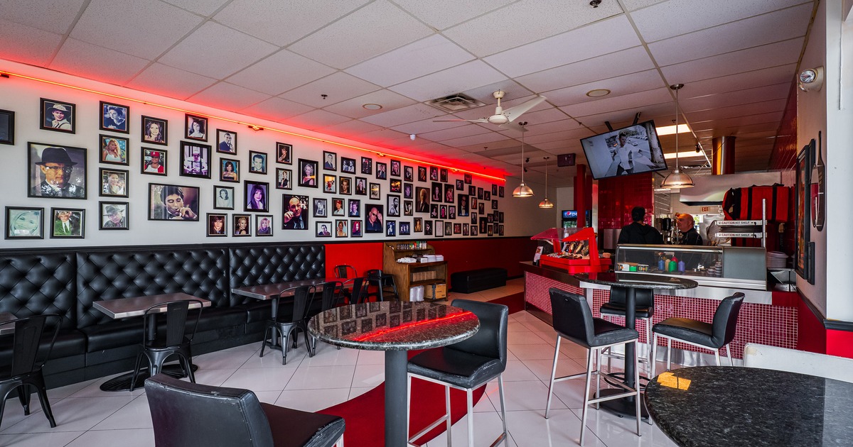 Interior space, seating area, framed photographs of celebrities on the wall and an order counter