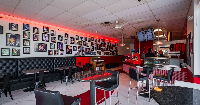 Interior space, seating area, framed photographs of celebrities on the wall and an order counter