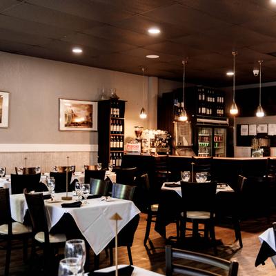 Interior featuring table and bar seating, hanging lights and framed artwork.