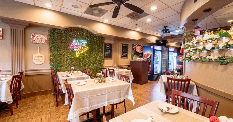 Warm and cozy restaurant interior dining area with dining tables set for guests