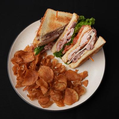 Club sandwich, with turkey, ham, sliced prime rib, bacon, jack cheese, and chips.