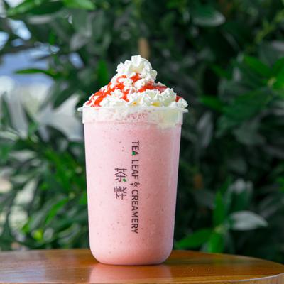 Strawberry Smoothie Tea on a table, with a greenery background.