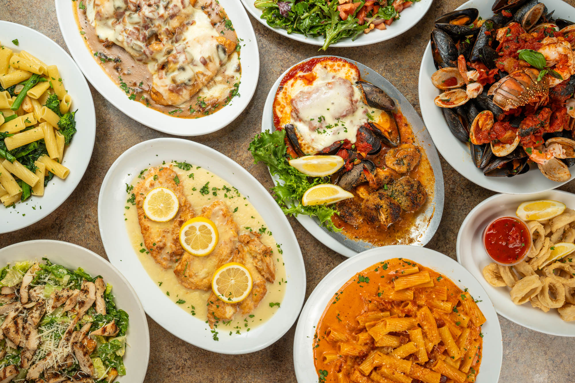Assortment of food plates spread on a table, top down view