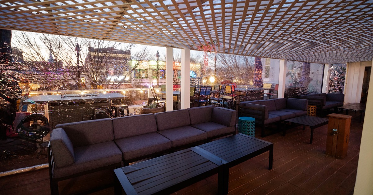Interior, rooftop terrace, four and three-seater sofas with wooden tables