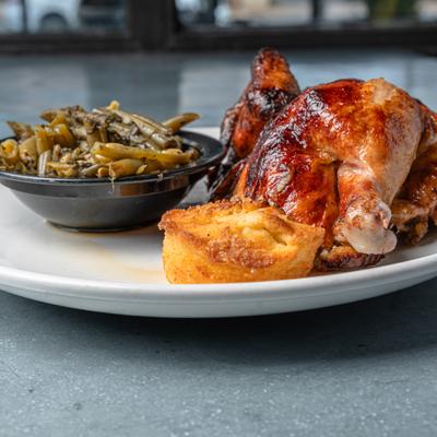 Rotisserie chicken with green beans and a piece of cornbread.