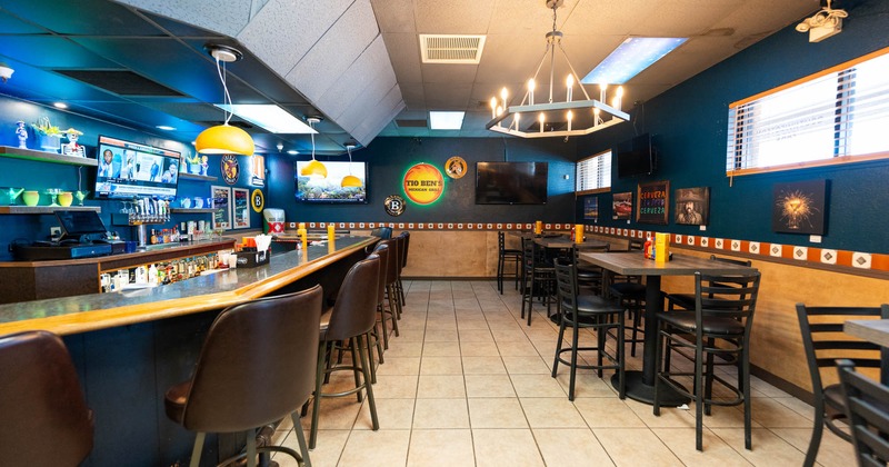 Interior, a bar ont he left, chairs with tables on the right