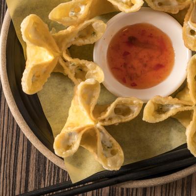 Cream cheese wonton with a dippin sauce, top view.