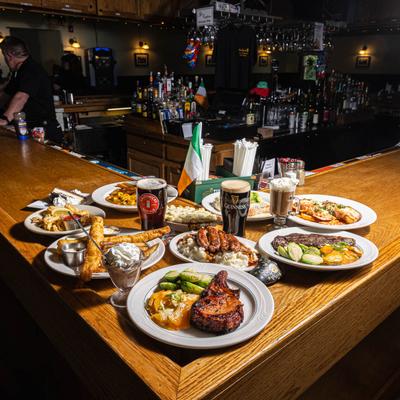 Large spread of traditional Irish pub dishes served on a bar counter.