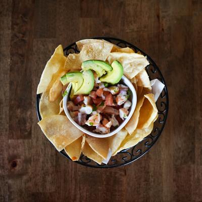 Shrimp and tilapia ceviche dip with avocado slices and chips img