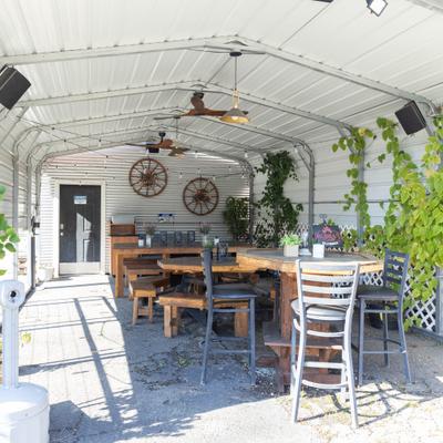 Outdoor covered patio dining area with wooden tables and benches.