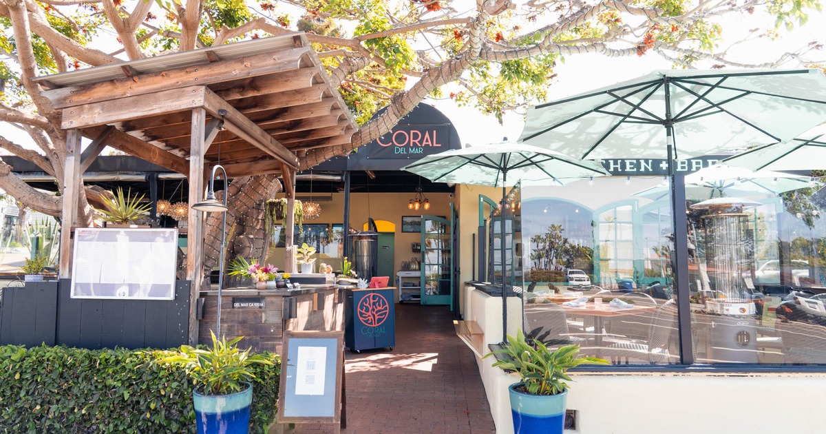 Exterior with signage, plants, and outdoor seating
