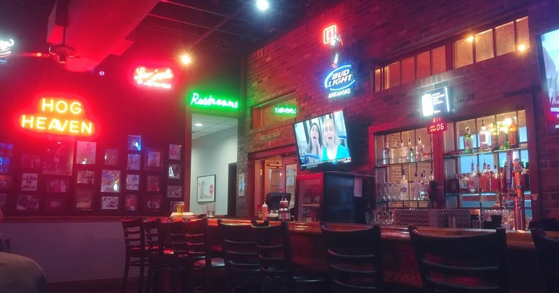 Interior, bar illuminated by neon light signs on walls