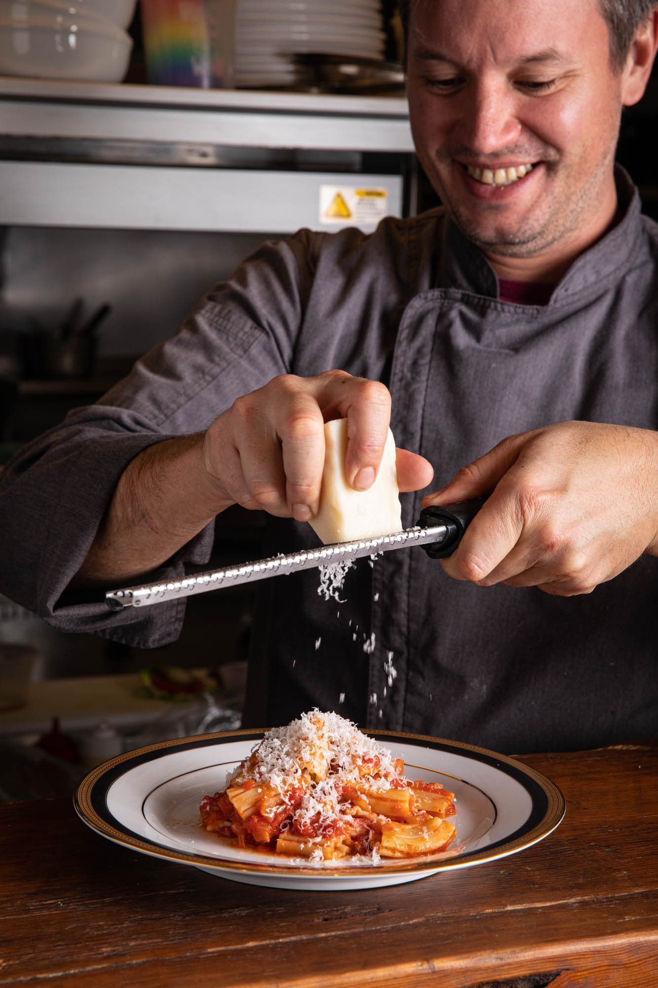 grating pecorino onto pasta