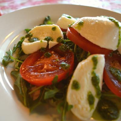 Caprese salad, with tomatoes, mozzarella, pesto, and basil