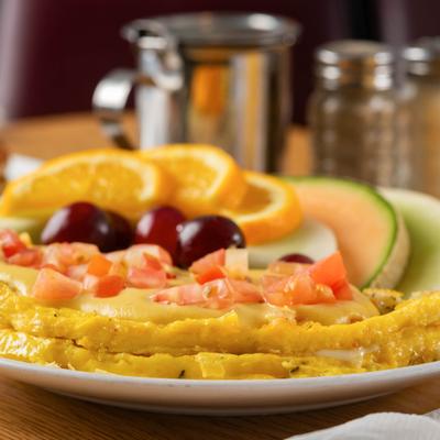 Seafood Omlette topped with diced tomato and served with fresh fruit.
