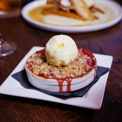 Berry crumble topped with a scoop of vanilla ice cream