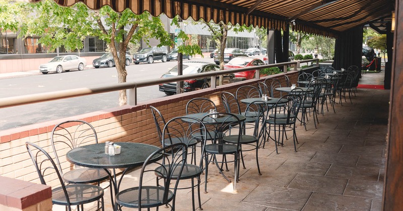 Covered seating area in front of the restaurant, tables and chairs