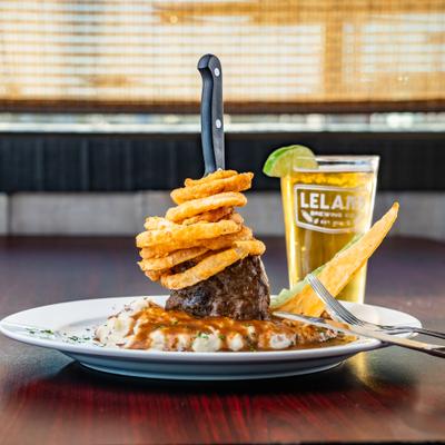 Meatloaf tower plate and a beer glass on a dark wooden table.