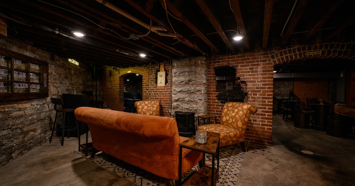 Interior, lounge area, stylish sofa and armchairs, stone and red brick walls