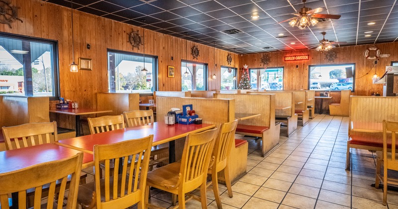 Big dining area with tables and  booths by the windows