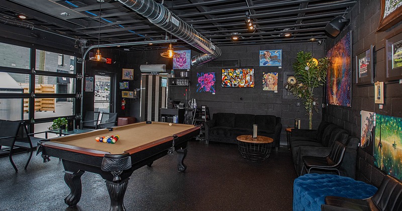 Interior, seating area, pool table in the middle of the room, pictures on the walls