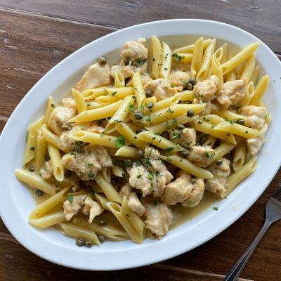 Penne pasta with chicken and capers in a light sauce.