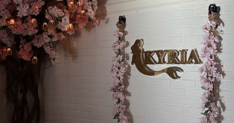 Softly lit restaurant tables set with wine glasses, white plates, and table lamps