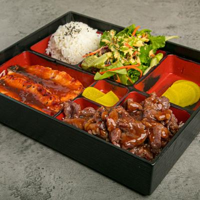Japanese bento box with rice, meat, fish, and salad.
